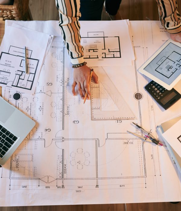 Female architect working on plan of the building, view from above